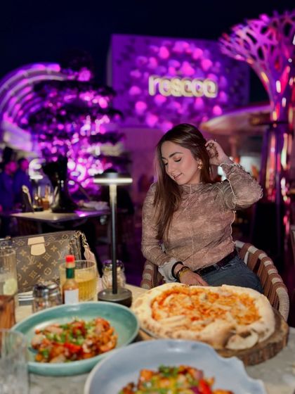 A great shot of the food and the vibrant purple-lit ambiance at Resaca Delhi. The rooftop vibe here is amazing.