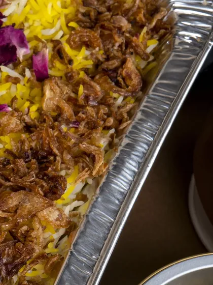A tray of my biryani topped with golden fried onions (birista), a key ingredient that adds a sweet, crunchy texture to the dish.