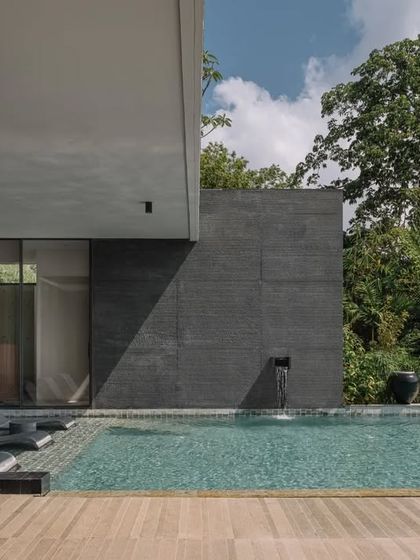 The clean, modern lines of the home's architecture contrast with the lush, organic forms of the surrounding landscape. The pool deck is designed for lounging and enjoying the connection to nature.