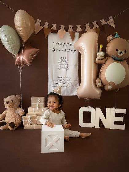 A happy, playful moment from the teddy bear session, with the birthday boy smiling beside his props.