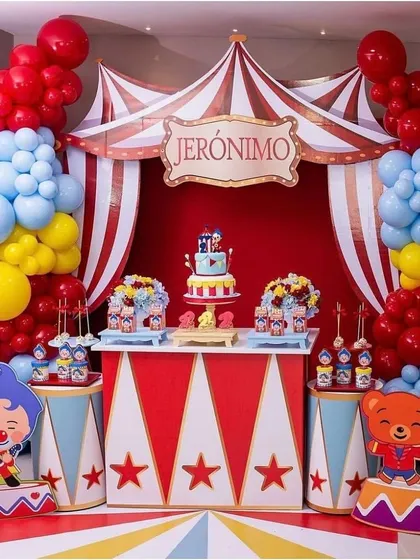 I designed this vibrant, circus themed birthday party for a child's celebration. The setup includes a custom backdrop with red and white stripes, a personalized "Jeronimo" sign, and colorful balloon garlands in red, blue, and yellow to create a fun and festive dessert table.