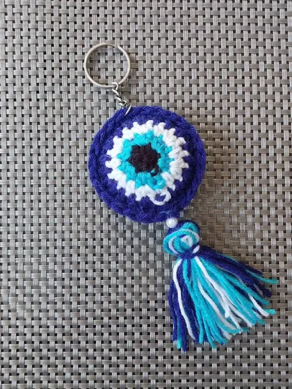 My signature evil eye keychain, handmade with love. This design is a customer favorite for return gifts and corporate freebies, featuring a crochet evil eye, a colorful tassel, and a small pearl for that extra touch.