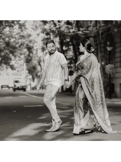 A timeless black and white photo of the couple crossing a city street, hand in hand. It feels like a scene from a classic movie.