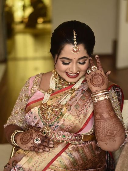 A beautiful, candid moment of a mom-to-be admiring her henna. The circular mandala design on her palm is a classic choice for baby showers, symbolizing life and completeness.
