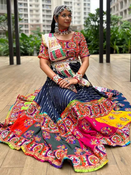 A full view of this stunning multi-panel chaniya choli. The striped blue skirt contrasts beautifully with the colorful patchwork border and embroidered blouse.