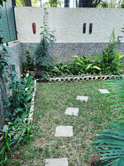 A small backyard garden with a stepping stone path and growing plants, showing the happy results of our work.