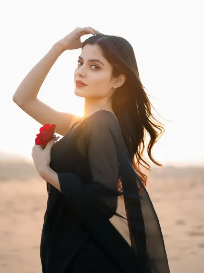 A classic portrait pose, looking directly at the camera with the sunset glow in the background.