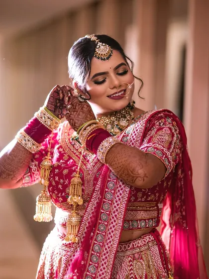 A happy, candid moment of the bride getting ready. Her makeup features a soft glittery eye and a dewy base, creating a natural yet glamorous look that lasted through all the smiles and celebrations.
