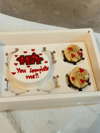 A romantic bento cake and cupcake set. The mini cake says "You complete me," and it's paired with two delicious cupcakes topped with heart sprinkles.