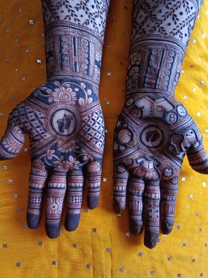 This baby shower design includes a variety of sweet elements. One hand has the baby feet, while the other features a cradle and the baby's initial, making it incredibly personal.