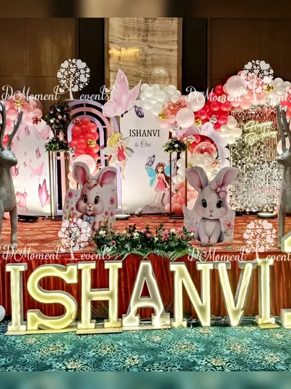 A whimsical winter wonderland stage that combines butterfly, fairy, and Christmas elements, featuring adorable bunny and reindeer props alongside marquee letters.