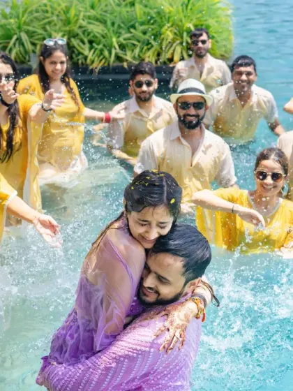 A joyous pool party where the couple and their friends celebrate together, splashing around in a moment of carefree fun.