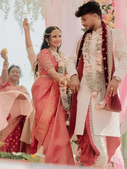 The couple takes their first steps together as husband and wife, showered with blessings and flower petals.