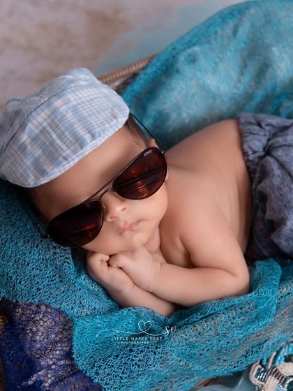 This little guy is too cool for school, rocking his sunglasses and cap. It's a fun, modern take on a newborn portrait that shows off a bit of attitude.
