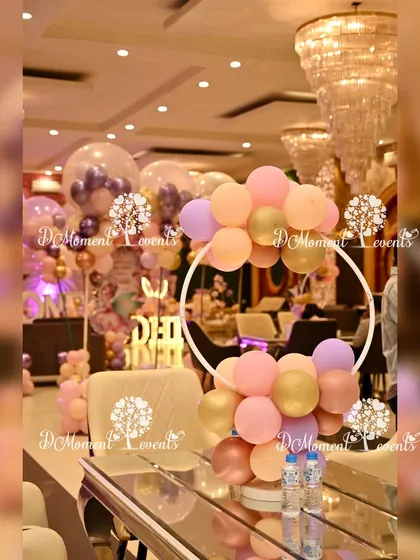 A table centerpiece featuring a white ring adorned with pastel balloons. This elegant detail helps carry the butterfly and fairy theme throughout the event space.
