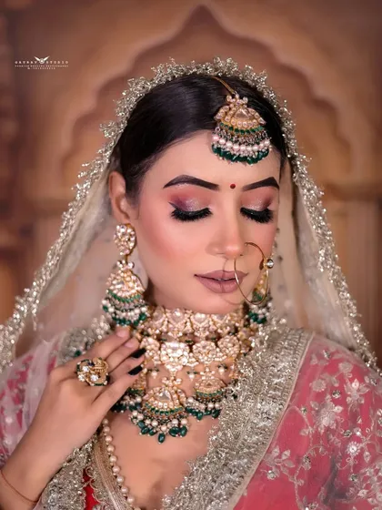 A soft and serene close-up, with the bride's eyes lowered, drawing attention to the makeup and jewelry details.