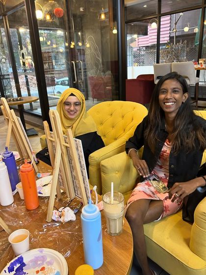 Two friends enjoying a relaxed painting session in a cozy cafe corner. I can set up a party almost anywhere!