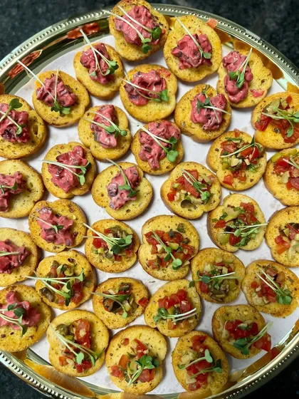 A platter of assorted bruschetta, a perfect finger food for the corporate luncheon. Toppings included classic tomato-basil and a creamy beetroot hummus.