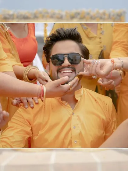 A fun, candid shot of the groom, Nikhil, surrounded by the hands of his loved ones applying Haldi, his big smile says it all.