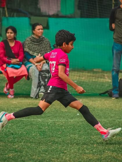 A player takes a powerful shot, his focus entirely on the ball.
