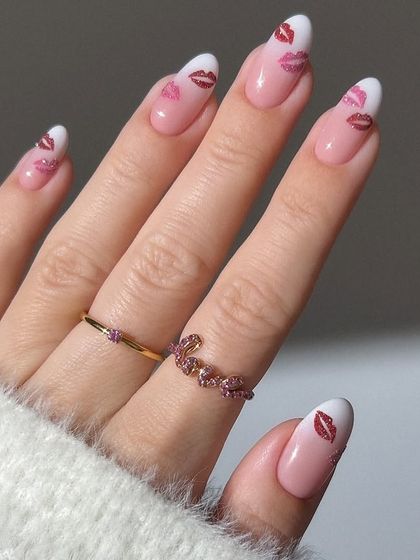 A fun and flirty Valentine's Day look featuring a white and pink ombre base with cute red glittery lip prints. This is a great example of a trendy, seasonal design.