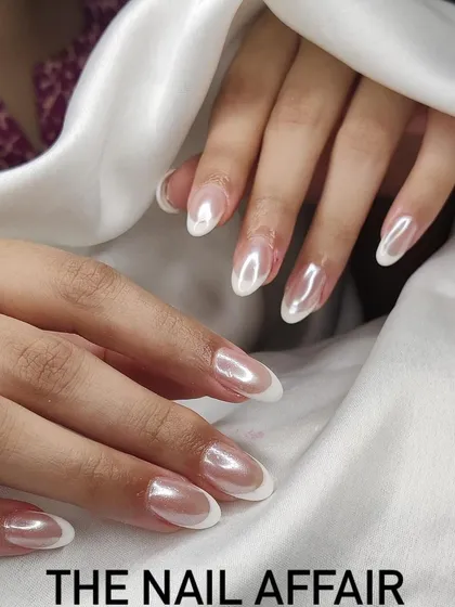 An elegant "glazed donut" or pearl chrome finish over a classic French manicure for a subtle, shimmery update.