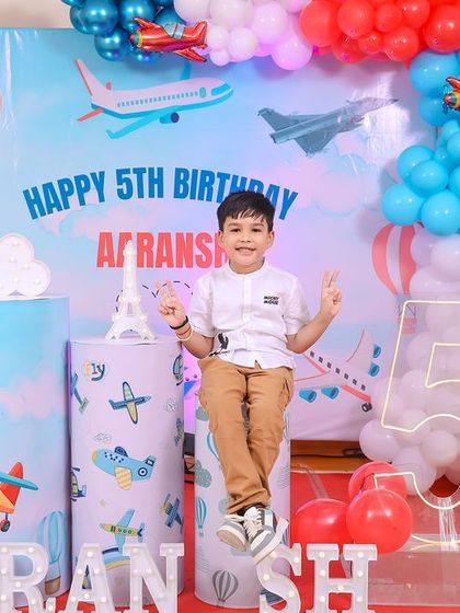 A thrilling 'Avengers' themed birthday party, with superhero cutouts, a cityscape backdrop, and dynamic balloon arrangements, ready for action.