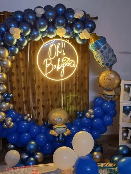 An "Oh Baby" moon-gate arch in blue and silver for a baby boy's welcome party.