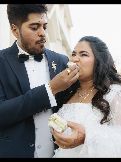 A playful moment of feeding cake at Malvin and Natalie's reception. Their expressions are candid and fun, showing the relaxed and joyful side of their celebration.