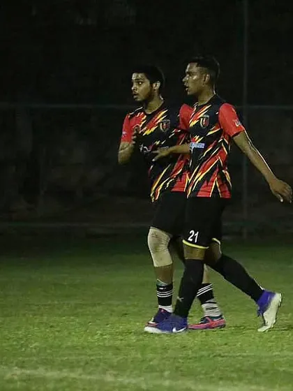Two of our players in sync on the field during a night match, demonstrating teamwork and communication.