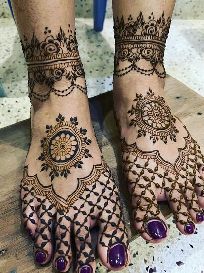 A simple yet elegant bridal design for the feet. The look is built around a central mandala, with a net-like jaal pattern extending over the toes and a floral anklet band.