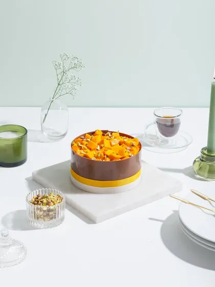 A mango cake with a rich chocolate collar, offering a beautiful contrast of colours and flavours.