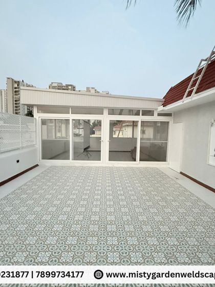 Another angle of the transformed terrace, showing the seamless integration of the indoor and outdoor areas with large sliding glass doors. The white lattice fence provides privacy while keeping the space bright.