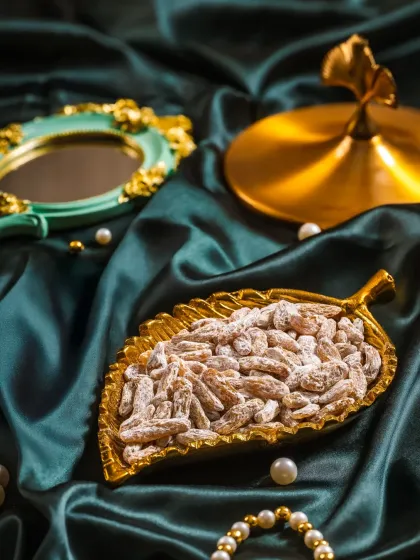 Raisin-e-Paan displayed out of the box in a decorative leaf-shaped dish, showing the product's texture.