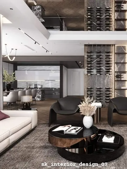 A spacious living area featuring a floor-to-ceiling wine rack as a statement piece. The contemporary low-slung chairs and sofa create a perfect setting for entertaining.