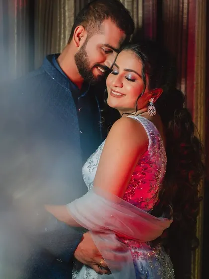 A romantic moment between the Sangeet couple. Her glamorous makeup, with a defined eye and glowing skin, is perfect for the evening's festivities.