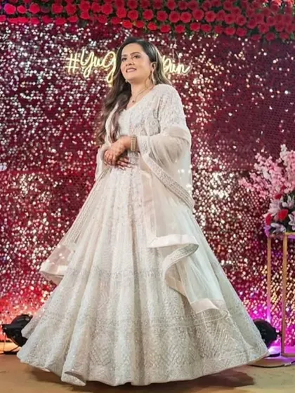 This couple's Sangeet look is pure elegance. The bride's makeup is soft and glowing, with her hair in romantic waves, perfectly matching the dreamy, fairy-light ambiance.