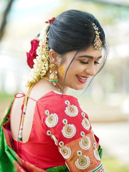 A beautiful candid shot of the mother-to-be, highlighting the intricate embroidery on her blouse and the traditional flowers in her hair.