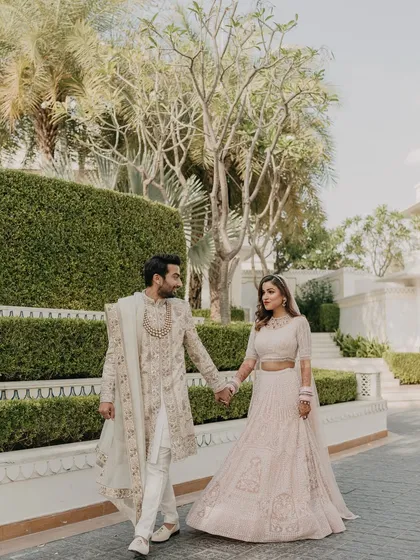 A beautiful shot of the couple walking along the manicured gardens of the palace. The blend of natural beauty and architectural grandeur is a hallmark of the venues I select.