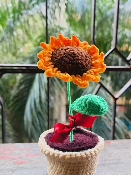 A close-up of the potted sunflower, showing the small red ribbon tied to its stem. It's these tiny details that I love adding to my creations.