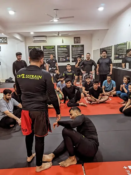 A coach provides feedback during a Jiu-Jitsu class. This personalized attention is key to helping our students overcome challenges and improve their game.