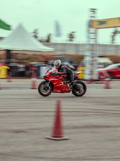 A wider view of the red Ducati on the track, with the event infrastructure in the background. We provide a professional and safe environment for these high-speed runs.