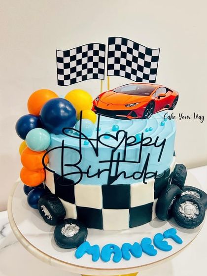 This cake's got more horsepower than a Lambo. A fun race car themed cake with checkered flags and fondant tires.