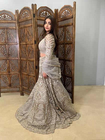 The side profile of this grey lehenga shows its impressive volume and the beautiful way the embroidered skirt drapes.