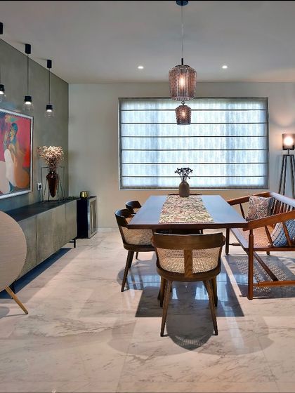 This dining space combines modern and traditional elements. Cane-back chairs and a wooden bench surround the dining table, while a mix of track lighting and a decorative pendant provides layered illumination.