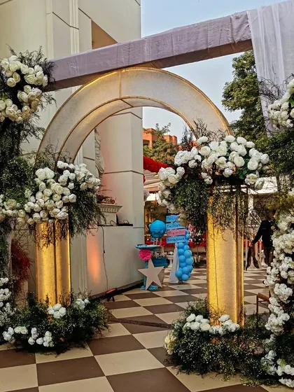 Elegance is in the details. This grand entrance arch, crafted with lush white florals and subtle gold accents, was designed to provide a luxurious and welcoming first impression for a high-end corporate milestone celebration.