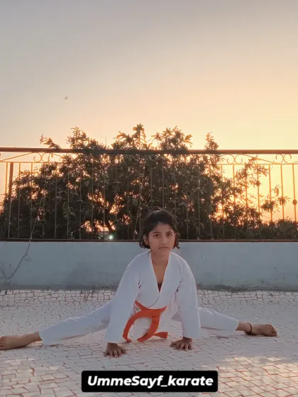 Flexibility is a cornerstone of karate, and we build it with consistent stretching and conditioning. This student demonstrates incredible dedication, mastering a full split against the backdrop of the evening sky. Practice makes you perfect.