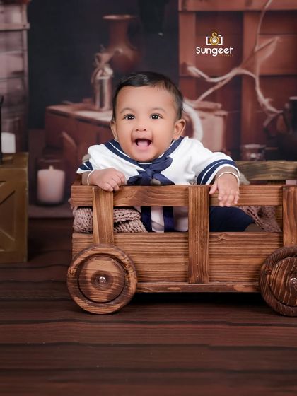 Ahoy, little sailor! This six-month-old is all smiles in our rustic wooden cart. Milestone sessions are perfect for fun themes that reflect your baby's adventurous spirit.