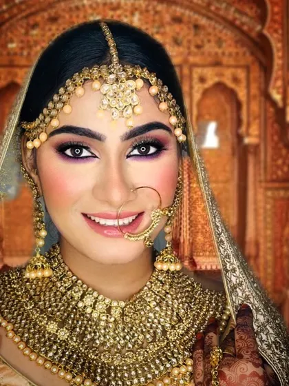 A smile that says it all. This contemporary bridal look combines a classic smokey eye with a pop of purple on the lower lash line, paired with a neutral lip to keep the focus on her expressive eyes.