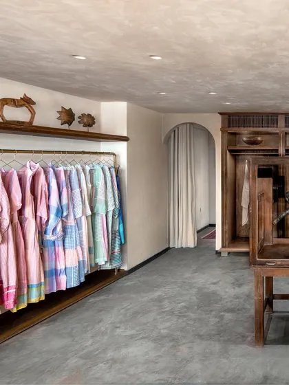 For the Eka fashion boutique in a Mumbai heritage building, we embraced a narrative of nostalgia and comfort. This space balances raw concrete floors with the warmth of natural wood displays and custom almira-style wardrobes, creating an intimate, home-like feel that reflects the brand's timeless values.